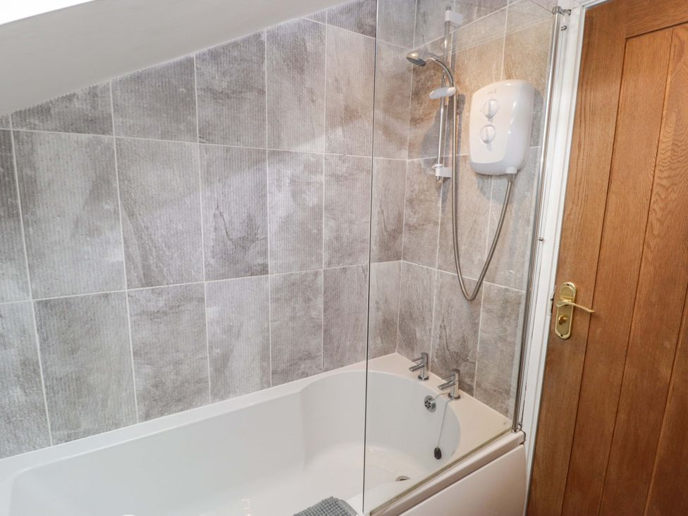 A bathroom with a bathtub and shower unit at No.8 Millmoor Farm Cottage Broad Haven