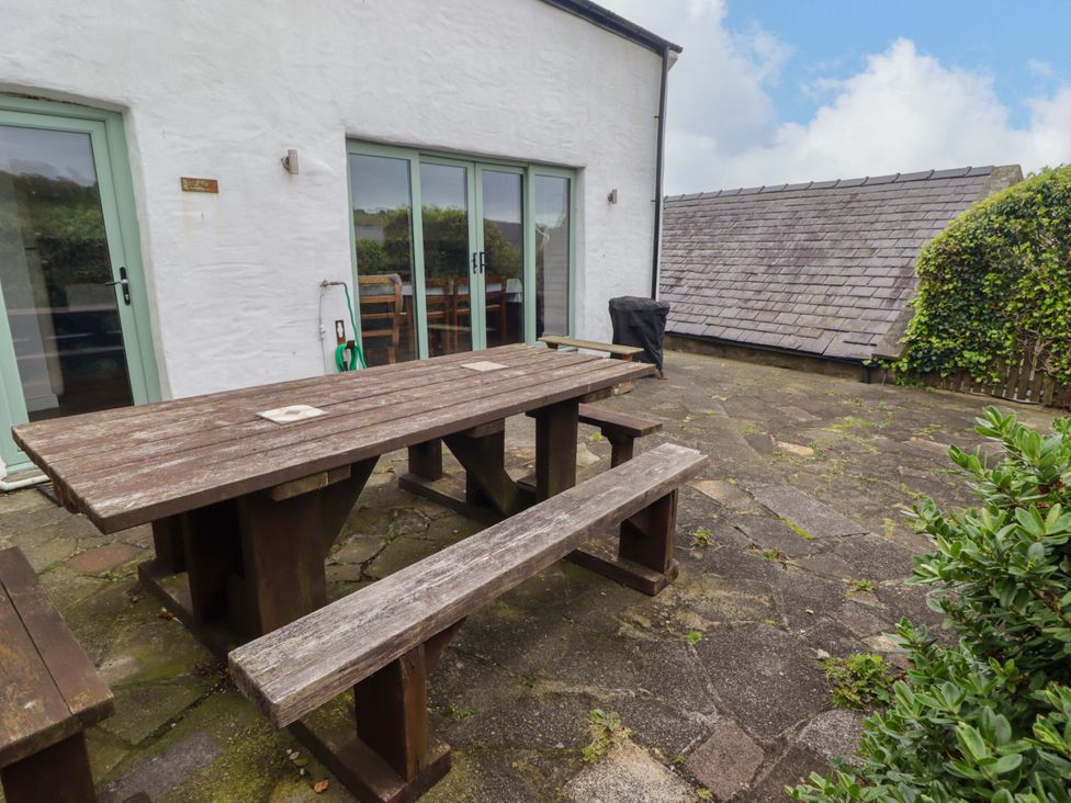 An outdoor area with a wooden table and benches at No.8 Millmoor Farm Cottage Broad Haven