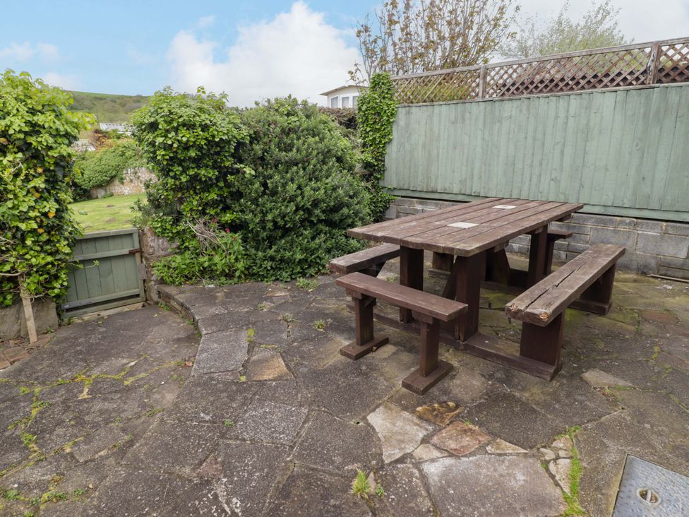 A garden with a wooden table and benches at No.8 Millmoor Farm Cottage Broad Haven