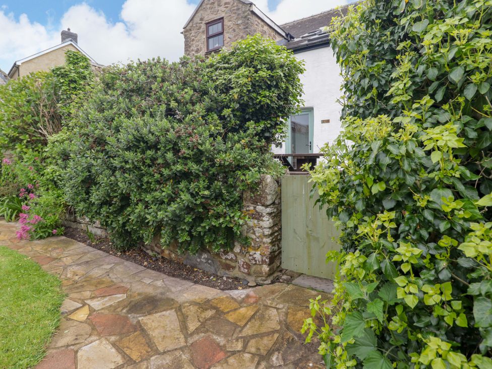 A garden pathway leading to a green gate at No.8 Millmoor Farm Cottage in Broad Haven