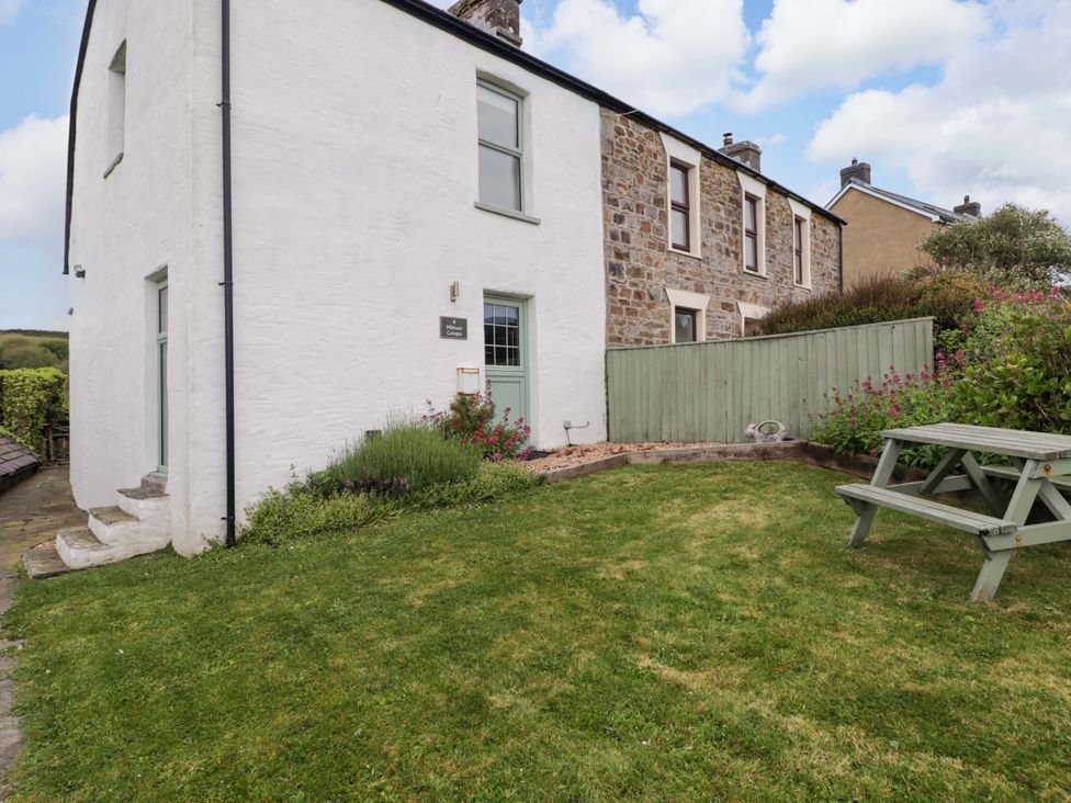An outdoor view of a house with a garden at No.8 Millmoor Farm Cottage in Broad Haven