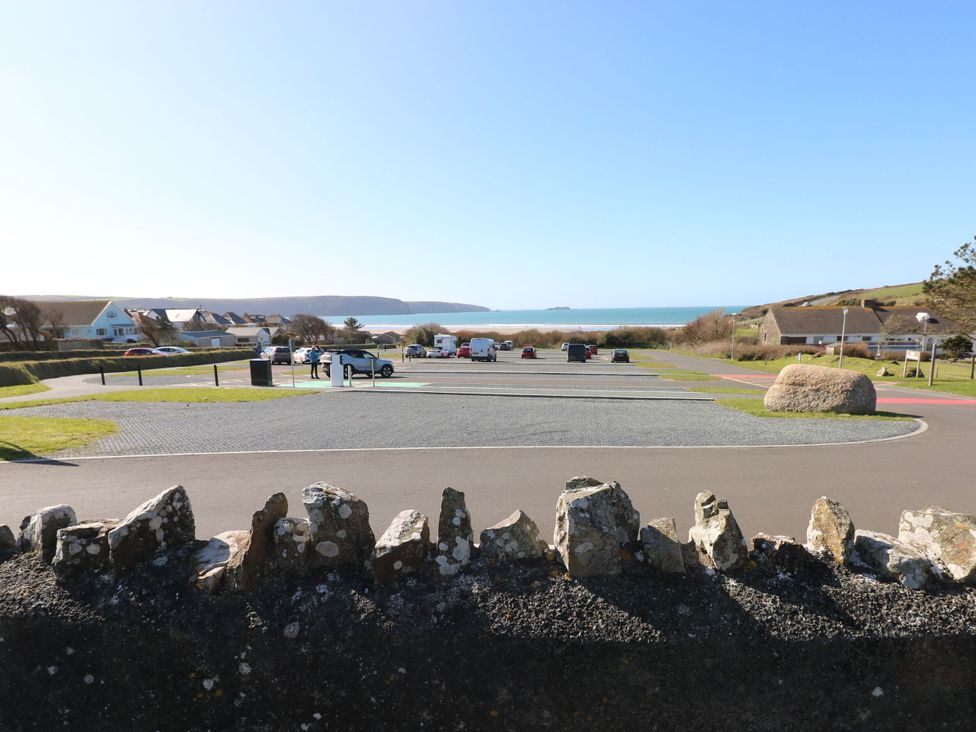A parking lot with vehicles near the ocean at No.8 Millmoor Farm Cottage Broad Haven