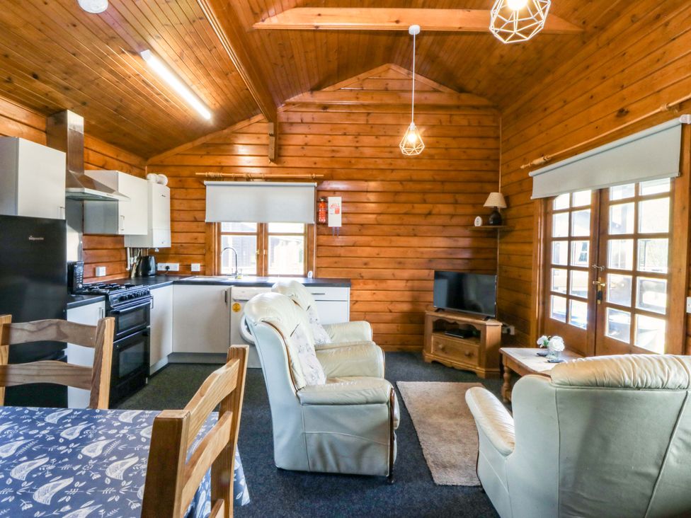 A kitchen area with seating and appliances at Lodge 1 - Bron Eifion Criccieth