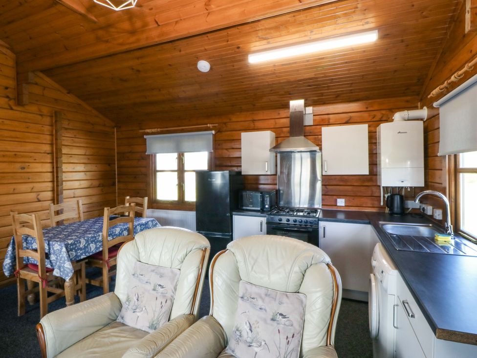 A kitchen with table and chairs at Lodge 1 - Bron Eifion Criccieth