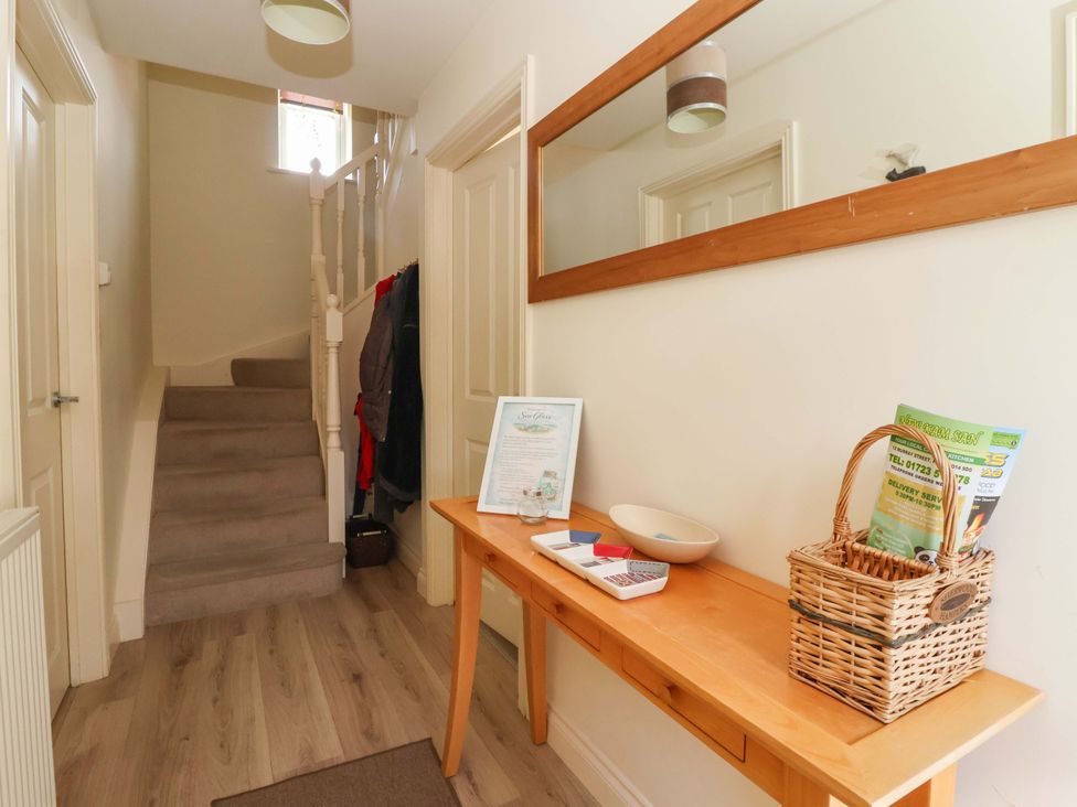 A hallway with a staircase and table at 4 Perran Court Filey