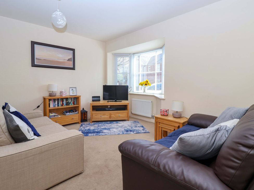 A living room with a television and bookshelf at 4 Perran Court in Filey