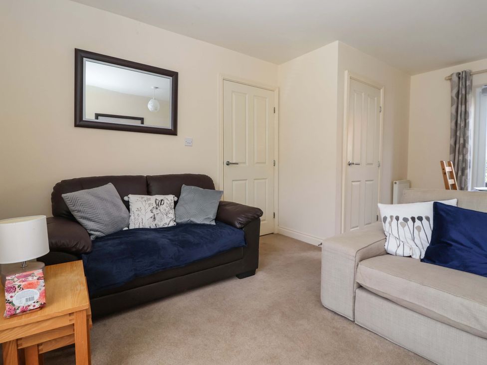 A living room with a sofa and a table at 4 Perran Court in Filey