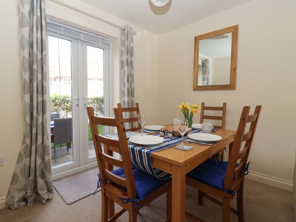 A dining room with a table and chairs at 4 Perran Court in Filey