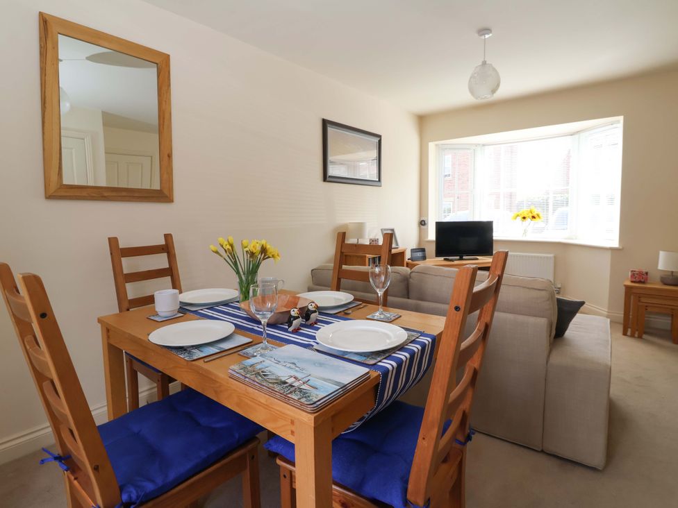A dining room with a table set for meals at 4 Perran Court in Filey