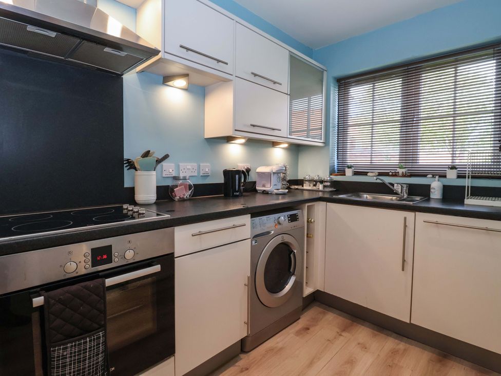 A kitchen with a washing machine and oven at 4 Perran Court in Filey