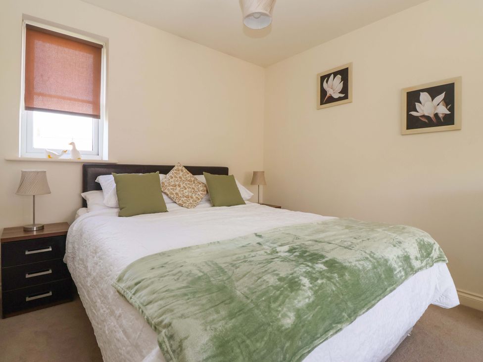 A bedroom with a bed and bedside table at 4 Perran Court in Filey