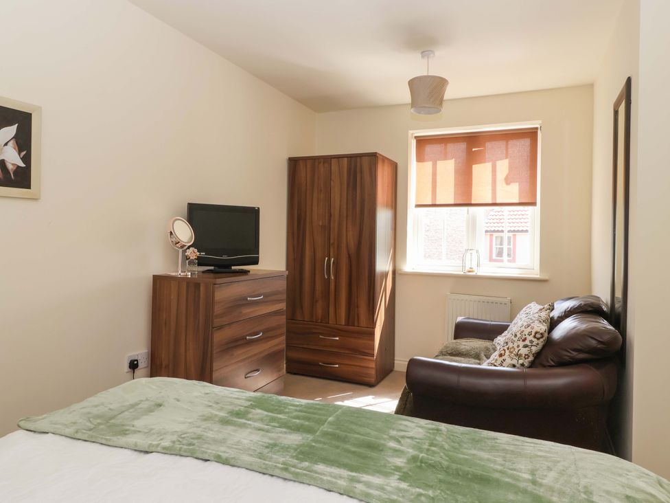 A bedroom with a bed and a dresser at 4 Perran Court, Filey