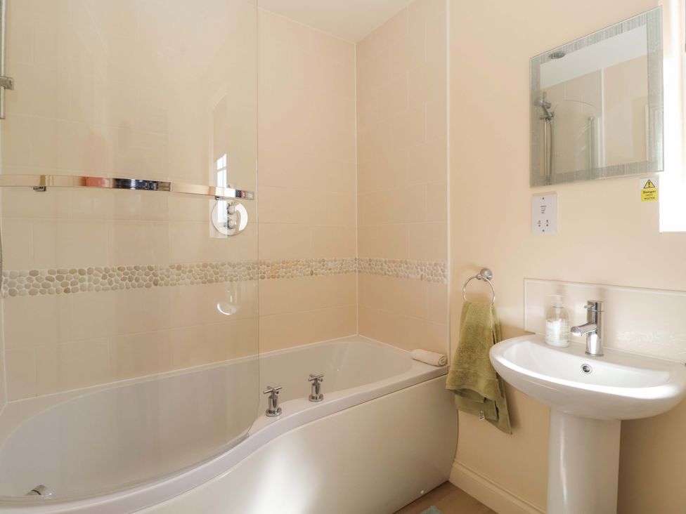 A bathroom with bathtub and washbasin at 4 Perran Court in Filey