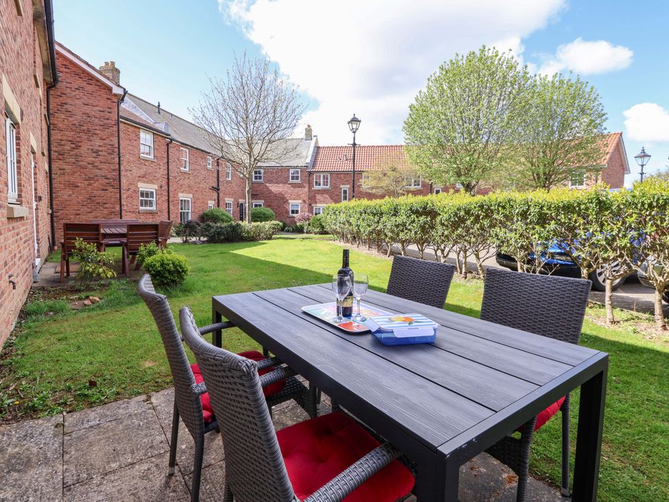 A garden with a table and chairs at 4 Perran Court in Filey