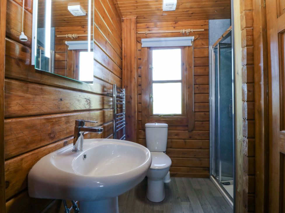 A bathroom featuring a sink, toilet, shower and mirror at Lodge 2 - Bron Eifion