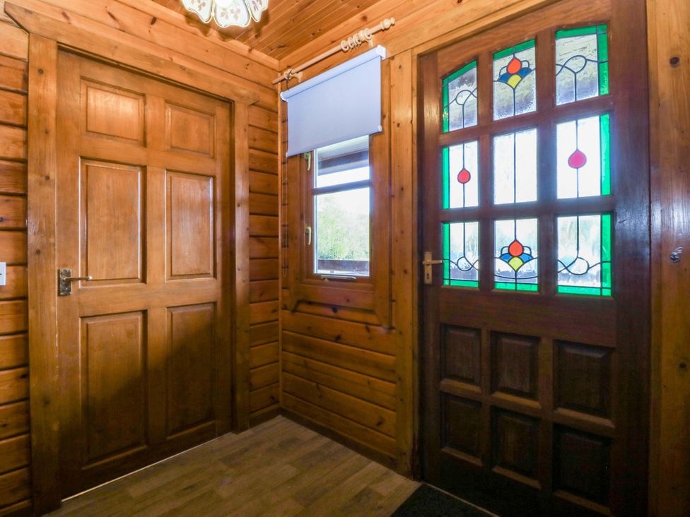 An entrance with a wooden door and stained glass door at Lodge 3 - Bron Eifion, Criccieth