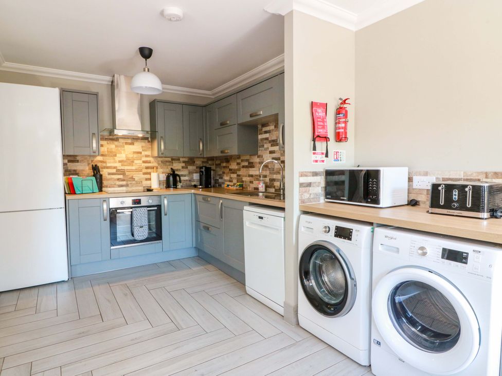 A kitchen with appliances including oven and washing machine at Ballaganlea in Alexandria