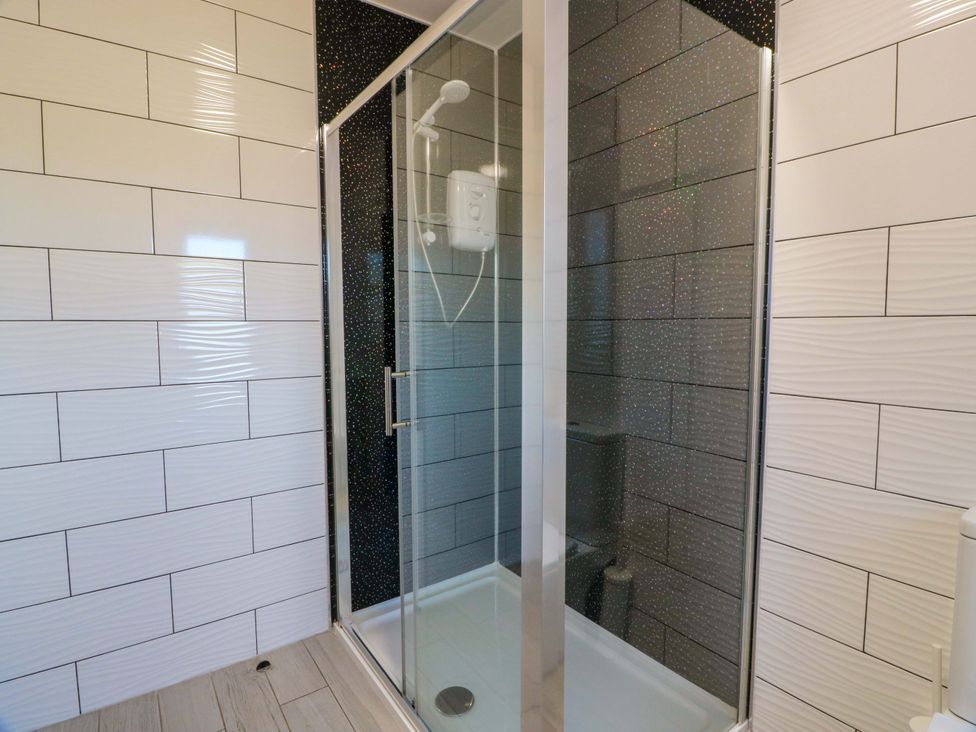 A bathroom with a shower enclosure and tiled walls at Ballaganlea in Alexandria