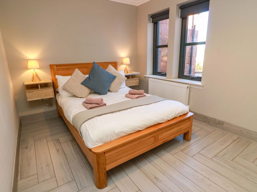 A bedroom with a bed and windows at Ballaganlea in Alexandria