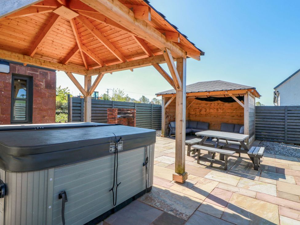An outdoor area with a hot tub and a seating area at Ballaganlea in Alexandria
