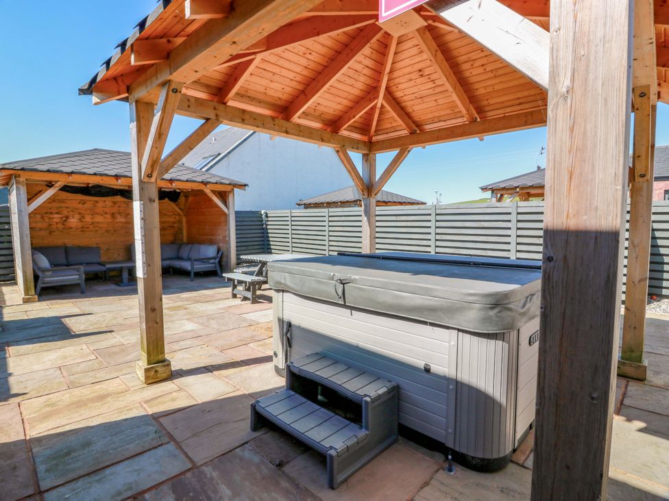 A garden with a hot tub and seating area at Ballaganlea in Alexandria