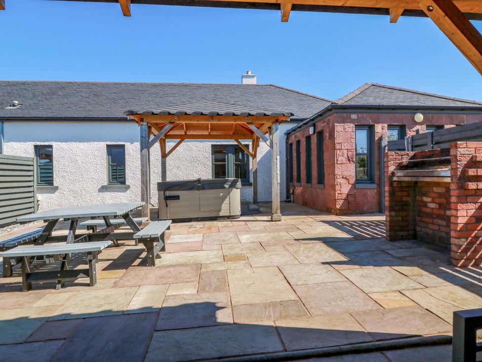 An outdoor area with a table and benches at Ballaganlea in Alexandria