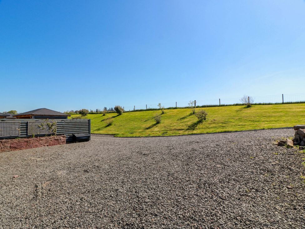 An outdoor area with a gravel surface and a grassy hill at Ballaganlea in Alexandria