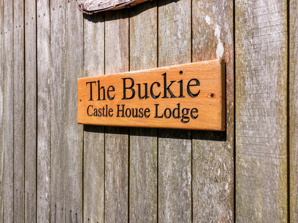 A wooden sign displaying The Buckie Castle House Lodge