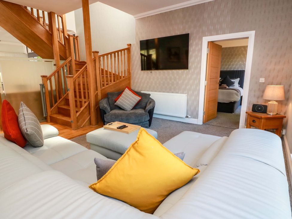 A living room with a sofa and stairs at Castle House Lodge in Glasgow