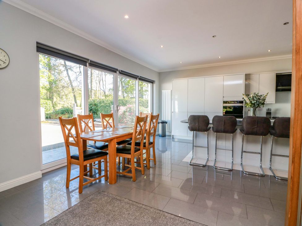 A kitchen with a dining table and bar stools at Castle House Lodge in Glasgow