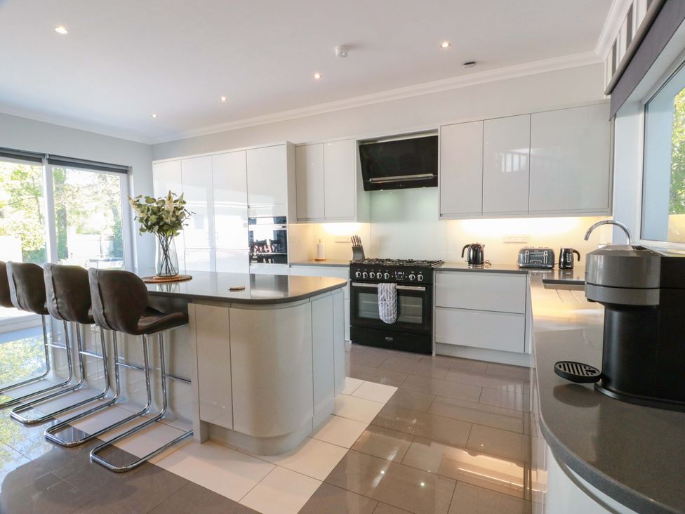 A kitchen with a countertop and bar stools at Castle House Lodge in Glasgow