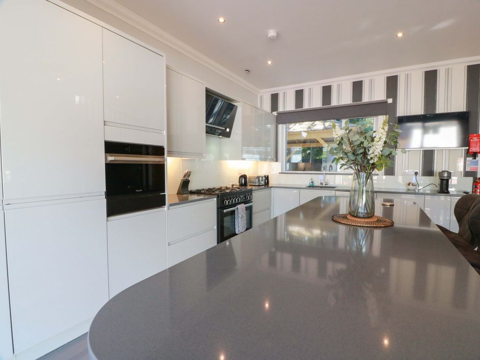 A kitchen with modern appliances and a vase of flowers at Castle House Lodge in Glasgow