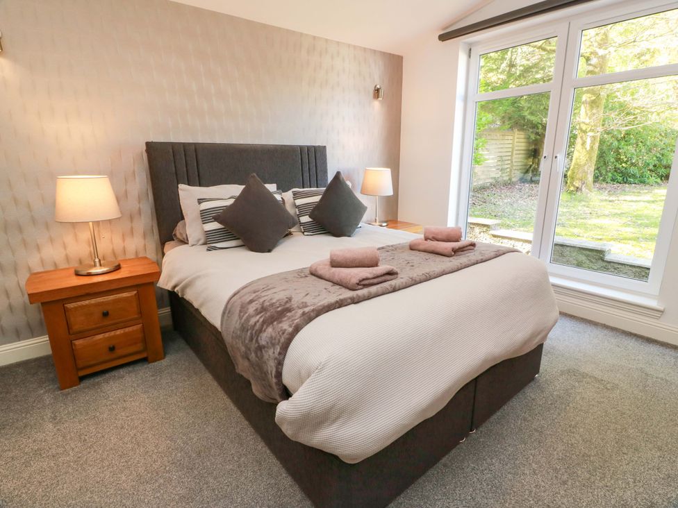 A bedroom with a bed and bedside table at Castle House Lodge in Glasgow