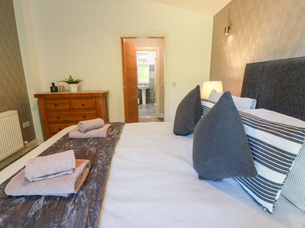 A bedroom with a bed and a dresser at Castle House Lodge in Glasgow