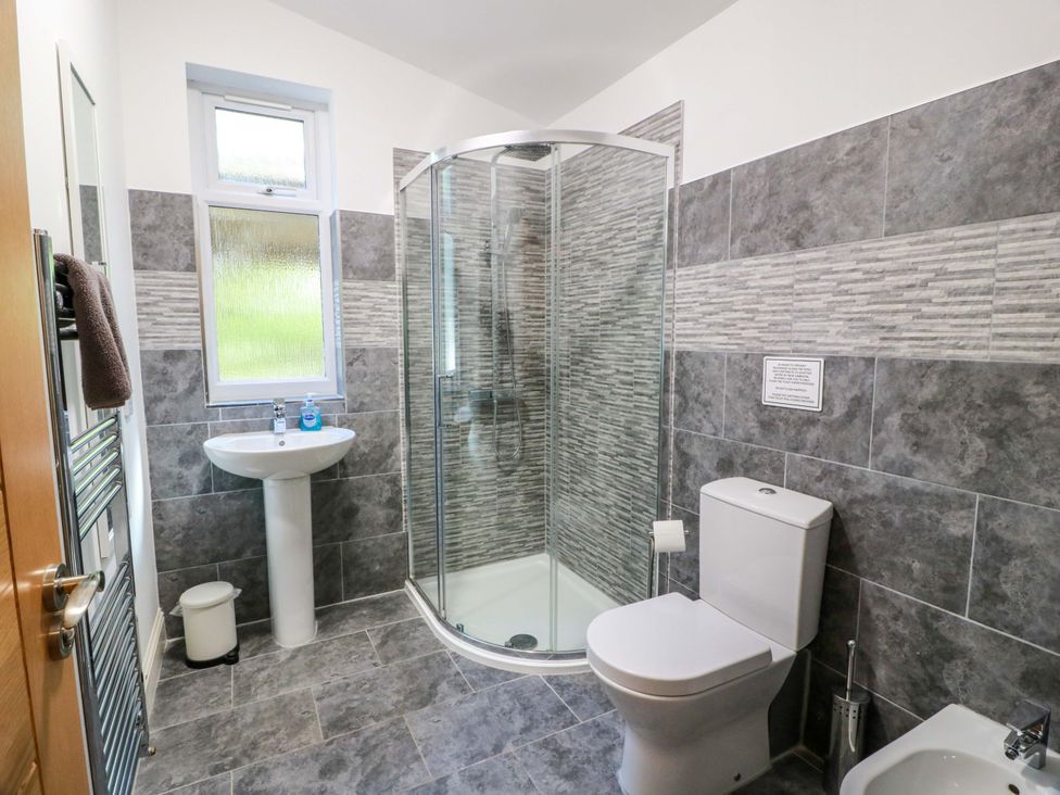 A bathroom with a shower, sink, and toilet at Castle House Lodge in Glasgow
