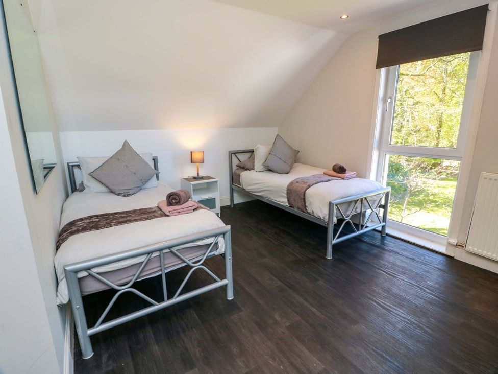 A bedroom with two beds and a window at Castle House Lodge in Glasgow