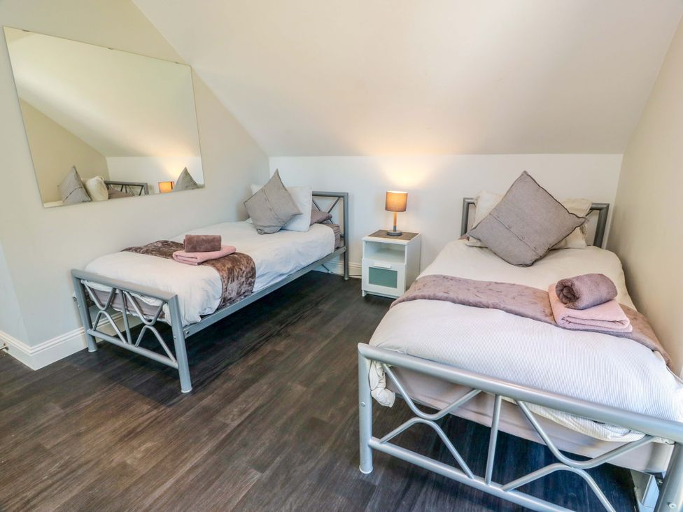 A bedroom with two beds and a mirror at Castle House Lodge in Glasgow