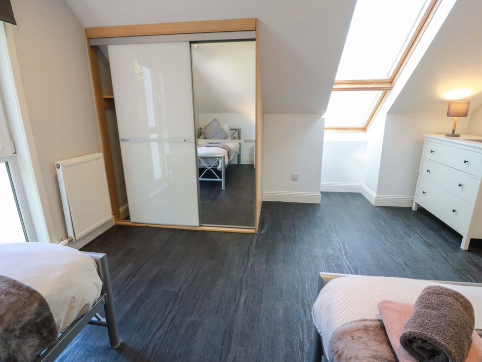 A bedroom with beds and a wardrobe at Castle House Lodge in Glasgow
