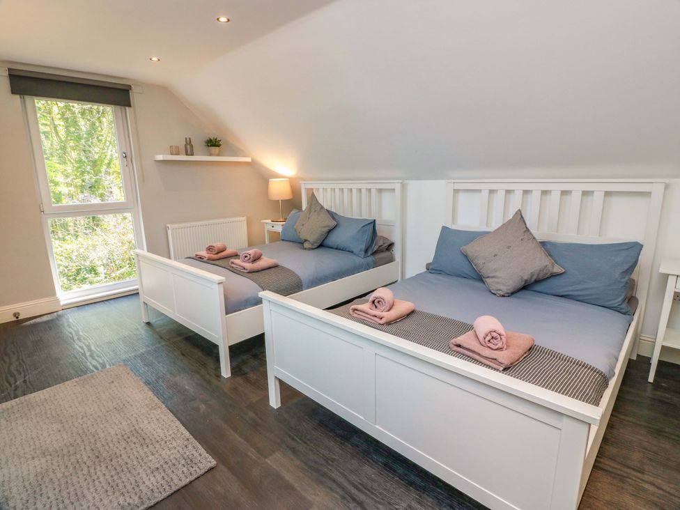 A bedroom with two beds and a lamp at Castle House Lodge in Glasgow