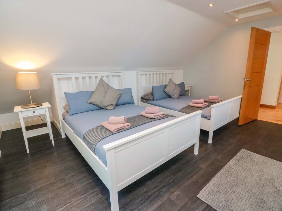 A bedroom with two beds and a lamp at Castle House Lodge Glasgow
