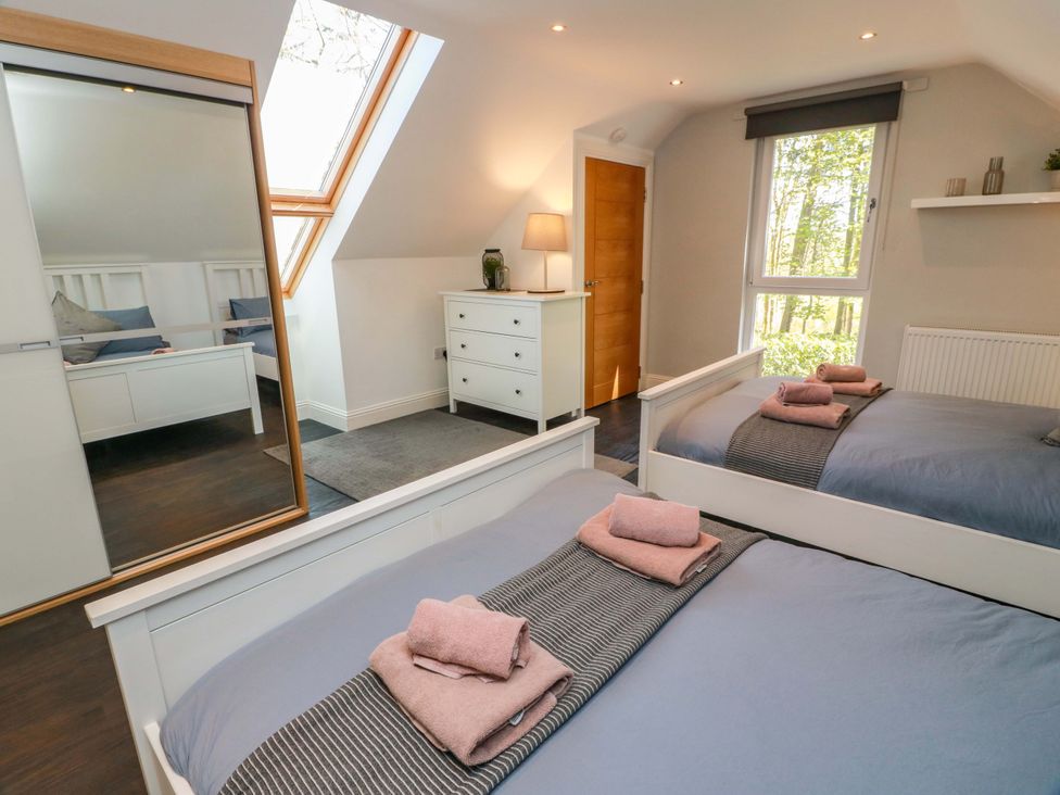 A bedroom with two beds and a dresser at Castle House Lodge in Glasgow