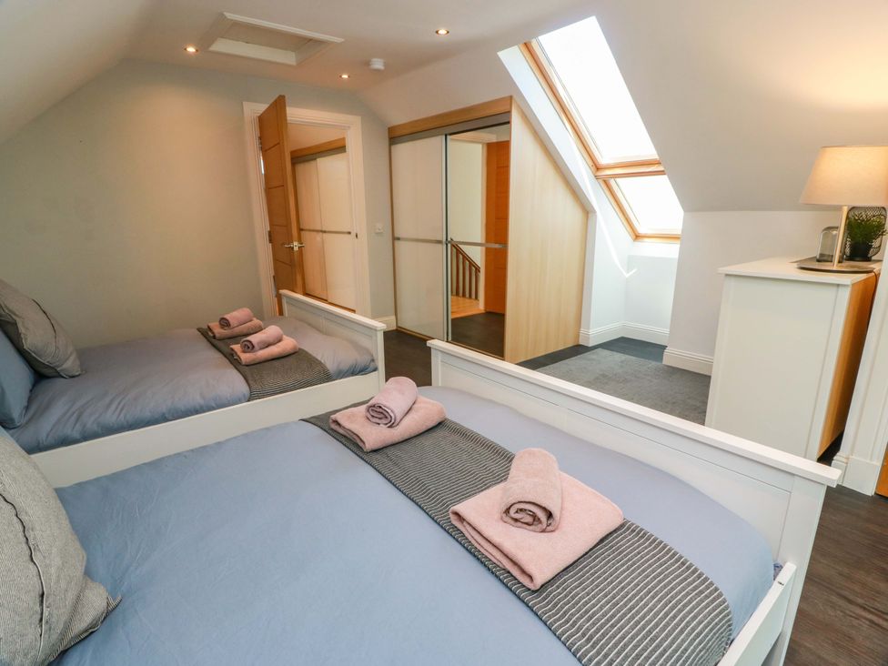 A bedroom with two beds and a wardrobe at Castle House Lodge in Glasgow