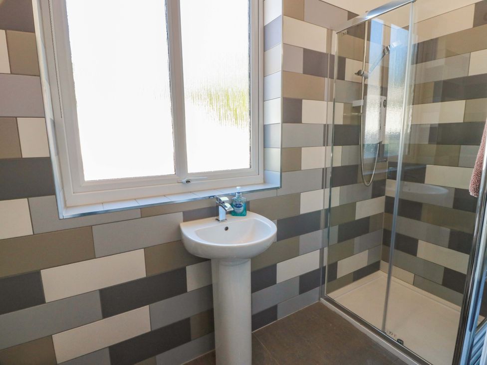 A bathroom with a sink and shower at Castle House Lodge in Glasgow