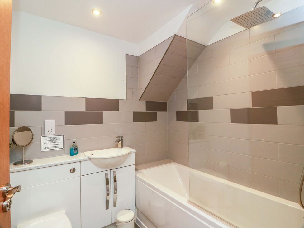 A bathroom with a bathtub, shower, sink, and toilet at Castle House Lodge in Glasgow