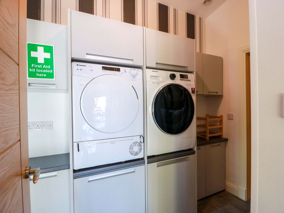 A laundry room with washer and dryer at Castle House Lodge in Glasgow