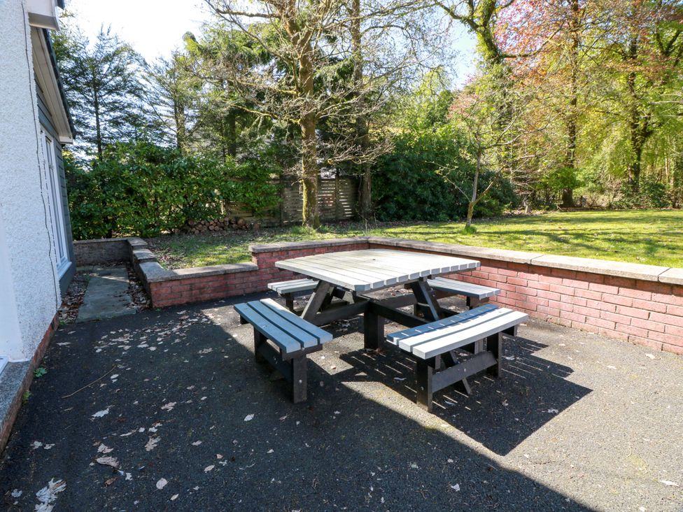 A picnic table with benches in an outdoor area at Castle House Lodge in Glasgow