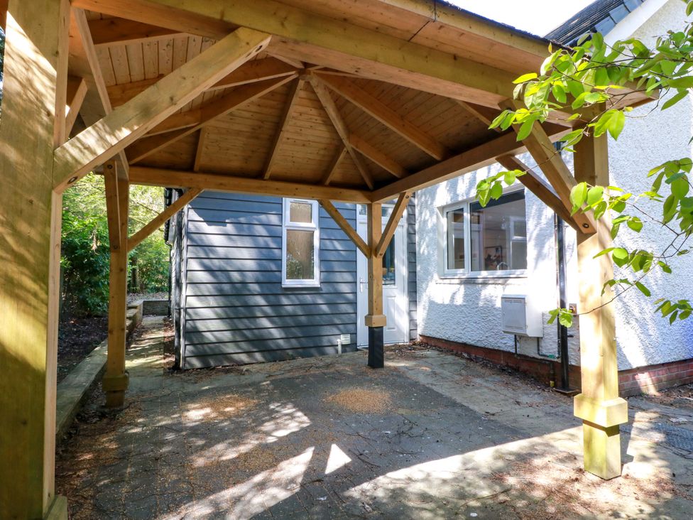 An outdoor structure with wooden beams adjacent to a house at Castle House Lodge in Glasgow