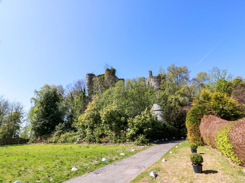 Ruins of a castle surrounded by greenery and a pathway at Castle House Lodge Glasgow