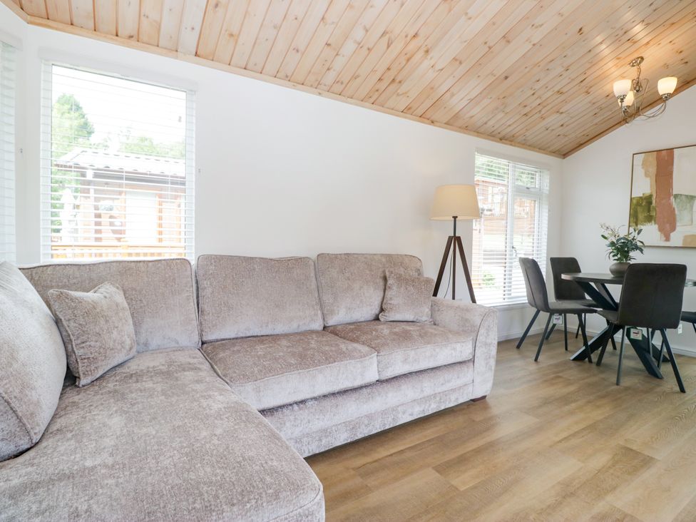 A living room with a sofa and dining area at Fox Red Retreat in Troutbeck Bridge