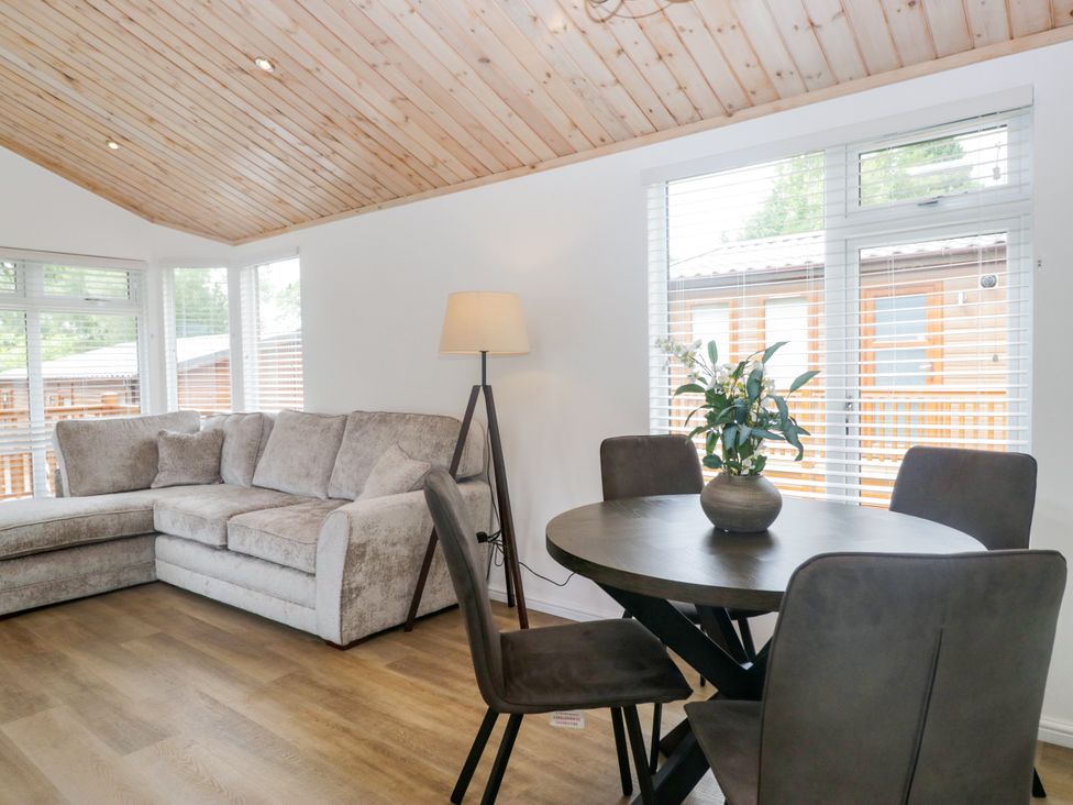 A living room with a sofa and dining table at Fox Red Retreat in Troutbeck Bridge